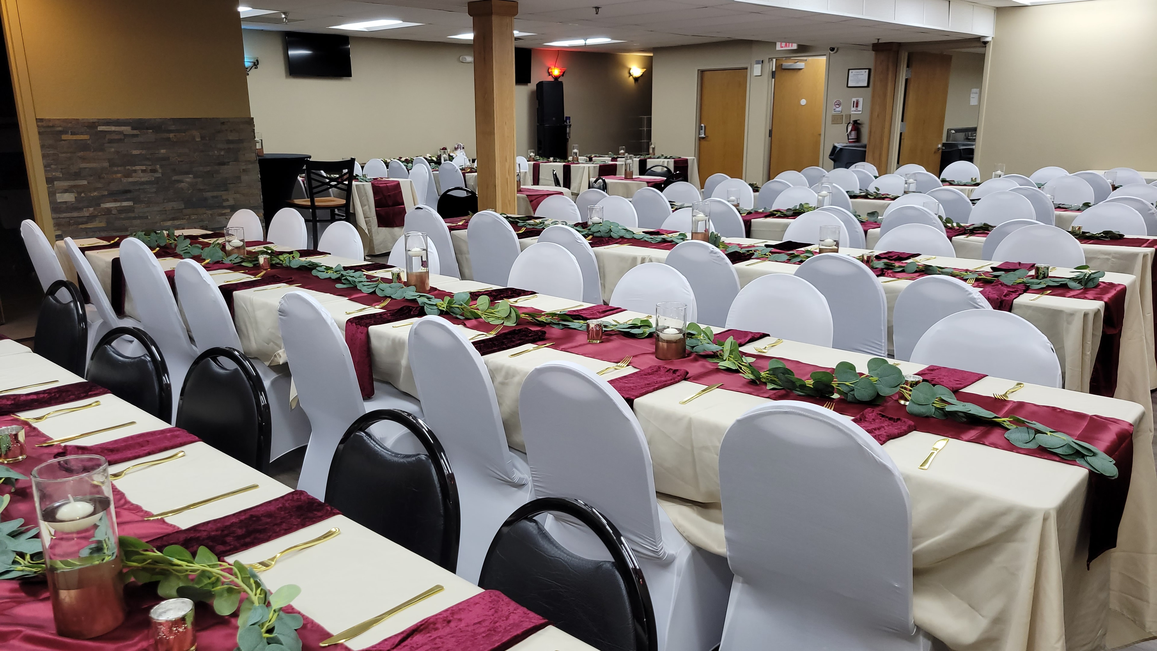 Corporate event room overview with formal table settings and white chair covers