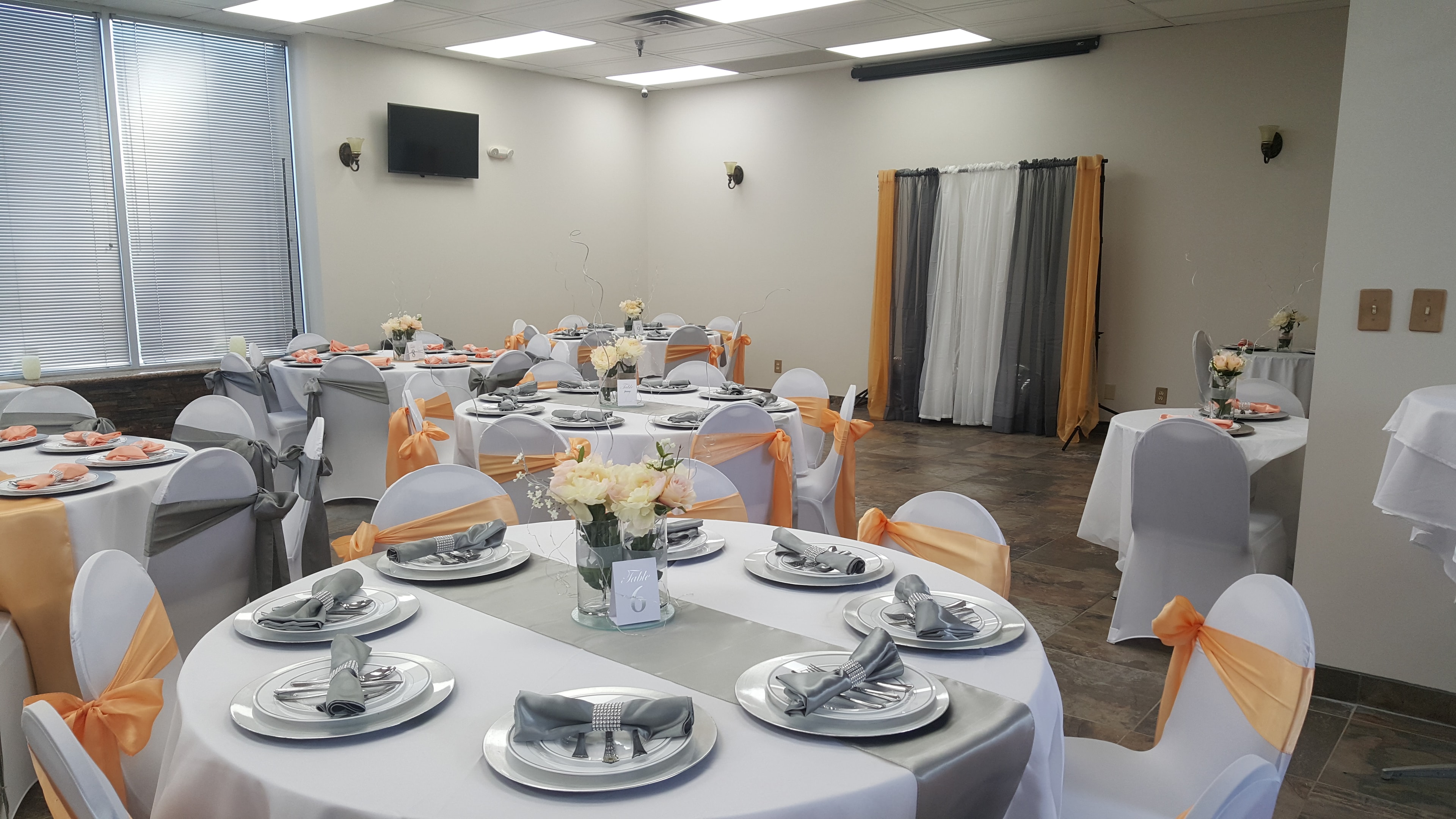Round reception table with peach and gray place settings at Deja Vu Event Space